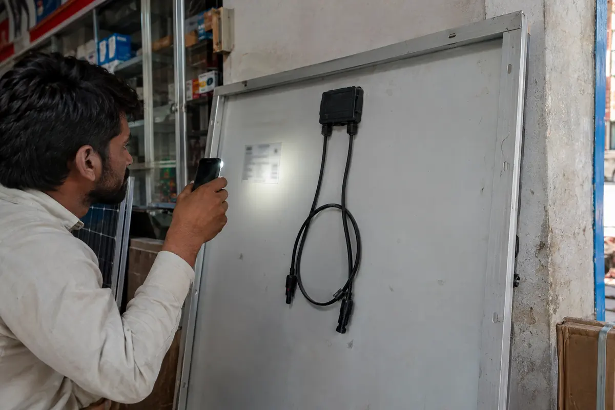 Checking the rear label of a 585 watt solar panel at a dealer shop